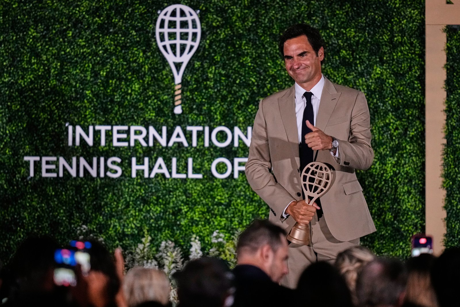 Roger Federer holds the International Tennis Hall of Fame trophy during his emotional induction cere